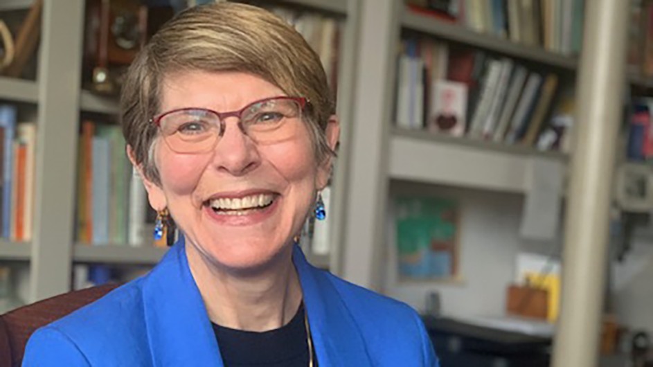 Columbia University Professor Andie Tucher, with short hair, eyeglasses, blue earrings, and a blue jacket.