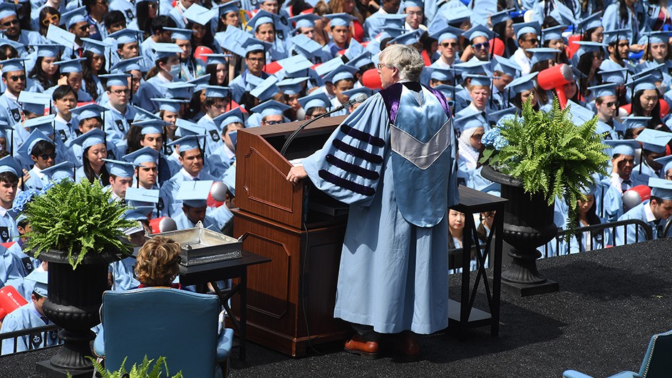 Photo: Eileen Barroso. President Bollinger addresses tens of thousands of guests and graduating Columbia students in light blue caps and gowns.