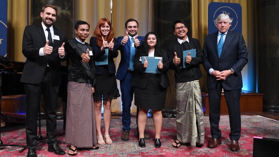 Staff members from Reuters (l to r): Simon Lewis, Kyaw Soe Oo, Poppy McPherson, Antoni Slodkowski, Shoon Naing, and Wa Lone accept a 2019 Pulitzer Prize for International Reporting from Columbia University President Lee C. Bollinger. Photo credit: Eileen Barroso President Bollinger, Wa Lone, Kyaw Soe Oo
