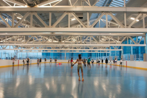 Roller skaters in a covered outdoor roller skating in Brooklyn Bridge Parl