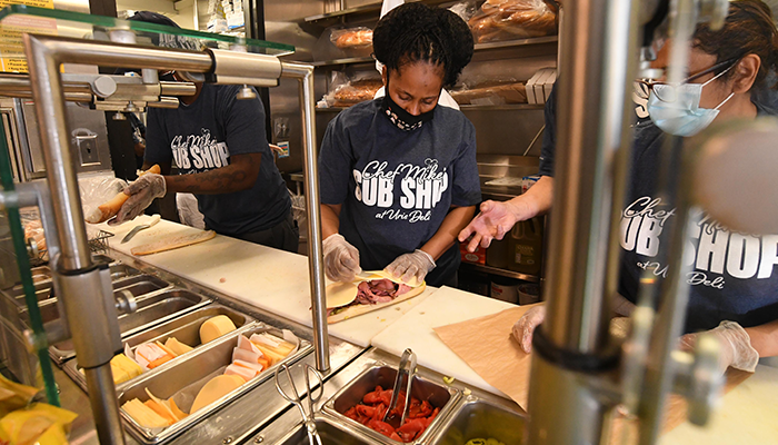 Three Columbia Dining workers prepare sandwiches