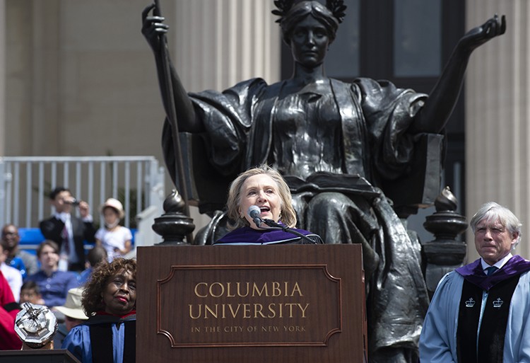 Responding to calls from graduates and guests for a speech, and with a nod from President Bollinger, honorary degree recipient and former U.S. Secretary of State and First Lady Hillary Clinton shared impromptu remarks with the Class of 2022 at Columbia’s Commencement ceremony. Photo by Diane Bondareff. Hillary Clinton gives a speech in front of Alma Mater.