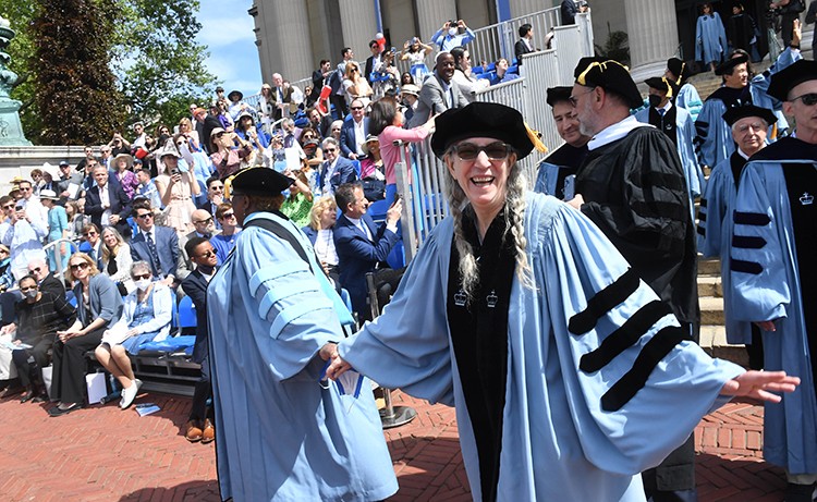 Gleeful honorary degree recipient, writer, performer, and visual artist Patti Smith, enters University Commencement during the academic procession. Photo by Eileen Barroso. Honorary Degree recipient Patti Smith enters in the processional to Columbia Commencement.