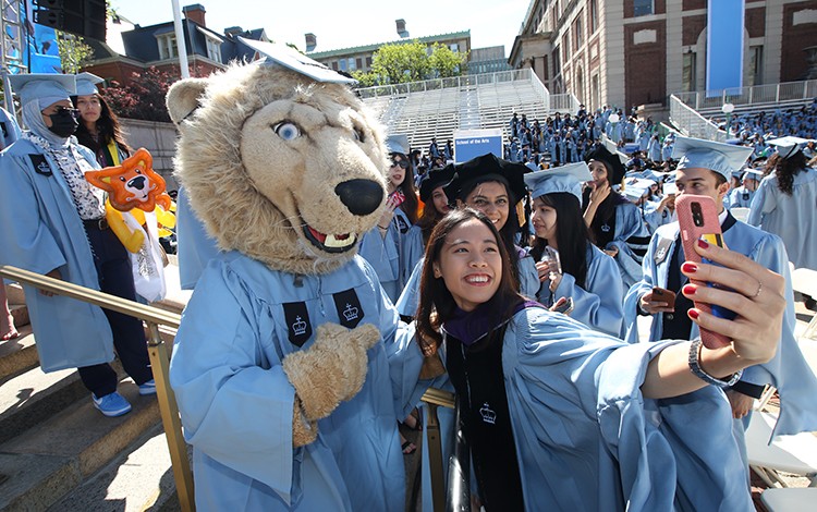 Roar-EE poses with a student during the academic procession