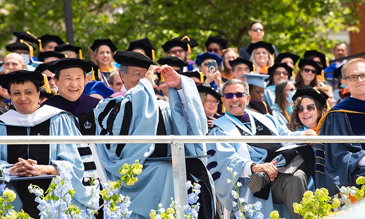 Honorary degree recipient, cellist, and humanitarian Yo-Yo Ma throws up a heart sign at the Class of 2022. Photo by Diane Bondareff. Honorary Degree recipient Yo-Yo Ma throw up a heart sign at the Class of 2022.