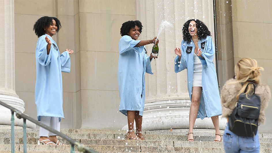 Students popping champagne on Low Library steps. 