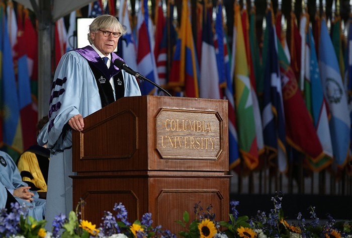 President Bollinger stands at a podium to address the Class of 2026 at Convocation.