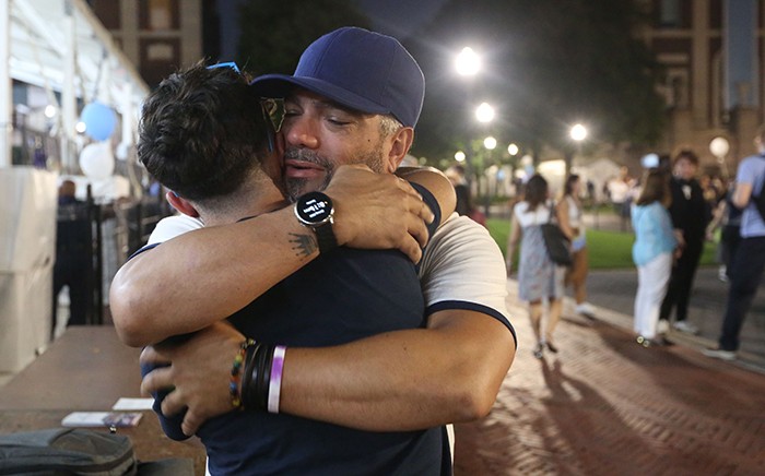 A man hugs his child goodbye at Convocation.