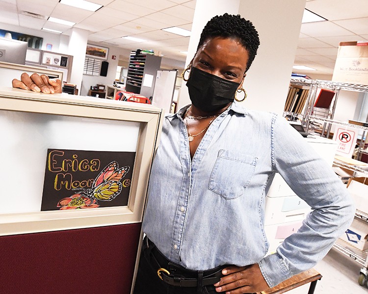 Erica Moor at her desk with Freddy Claudio's butterfly art.