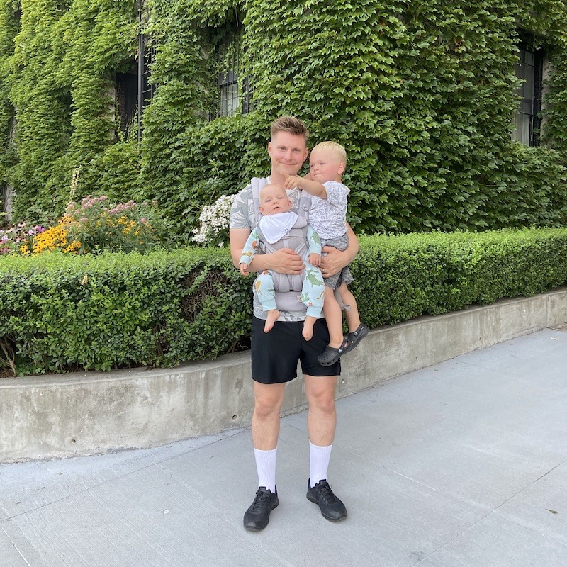 Gunnar Thorsteinsson standing and holding his two young children