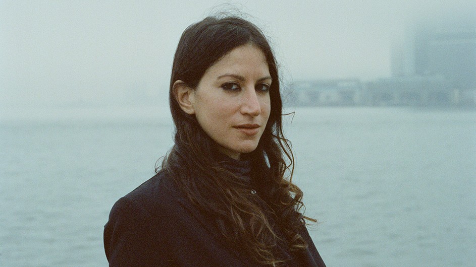 Adjunct Writing Professor Hannah Assadi, Columbia University School of the Arts, stands before water