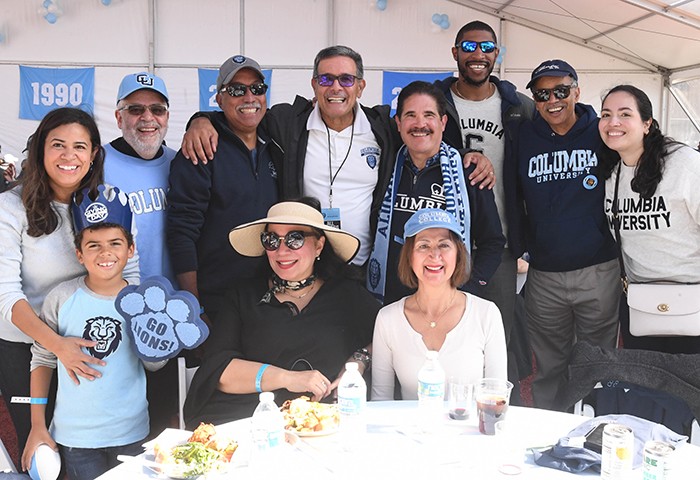 Homecoming festivities included welcoming home alumni, including Columbia Trustee Rolando T. Acosta (CC'79, LAW'82), pictured center. Photo by Eileen Barroso/Columbia College. A group of Columbians under a tent.
