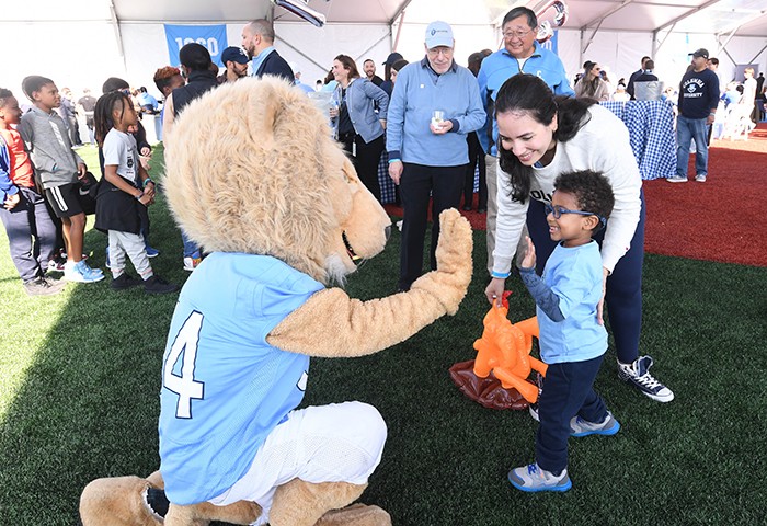 A young Columbian gives a high-five to Roar-ee. 