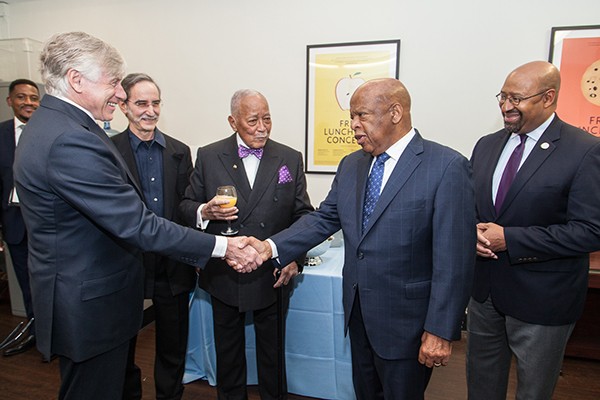 A group of men greet each other. 