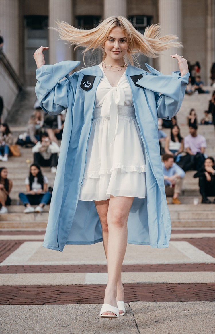 Maya Kashapov (CS'22) is part of the inaugural class of Columbia Climate School graduates. Courtesy Maya Kashapov. Maya Kashapov flips her hair in regalia.