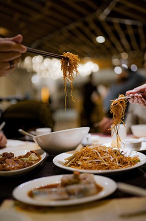 Noodles on a plate and noodles on chopsticks.