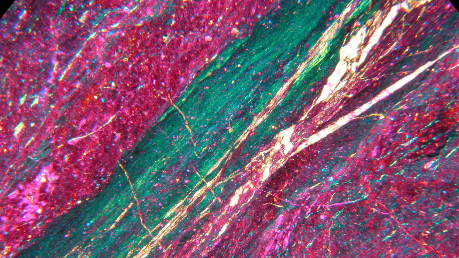 Microscope view of rock structurally altered during an earthquake; green layer was heated during fault movement. (Kelly Bradbury/Utah State University)