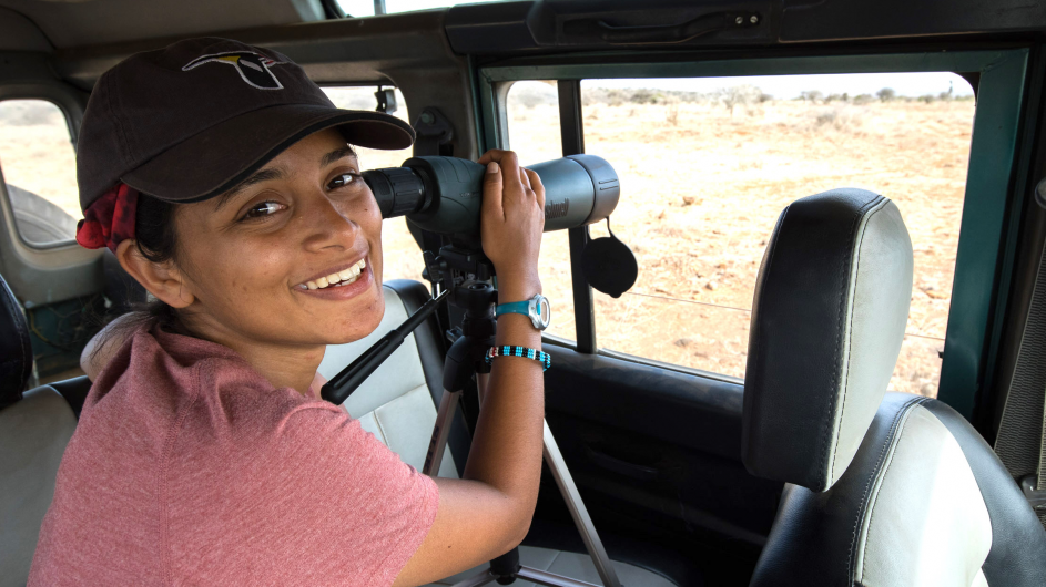 Shah spent a full year and a half observing superb starlings in the field. Photo courtesy of Shailee Shah. Columbia PhD student Shailee Shah watches birds through binoculars.