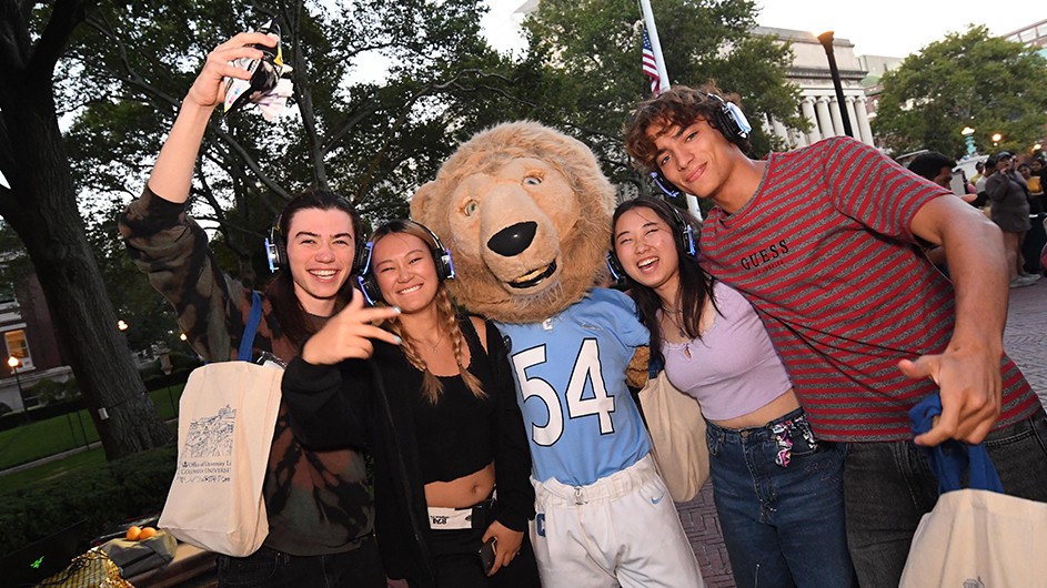 Students pose next to Roar-ee at a Silent Disco.