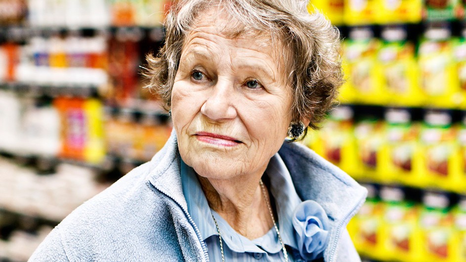 An older woman in a grocery store aisle.