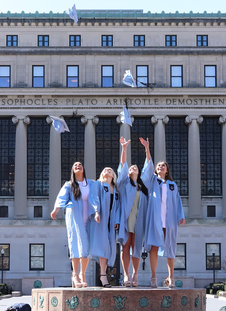 Maria Shakespeare, Francesca Crawford, Katherine Barrett, Julia Baran throw their hats on the sundial in front of Butler Library.