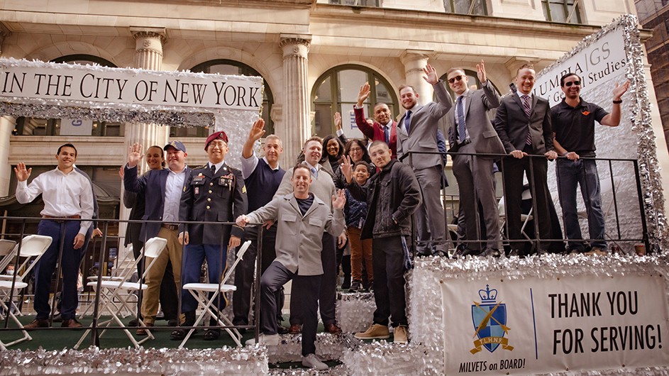 Columbia General Studies military veteran students waving on a parade float with Dean Lisa Rosen-Metsch at the 2021 Veterans Day Parade in New York City.