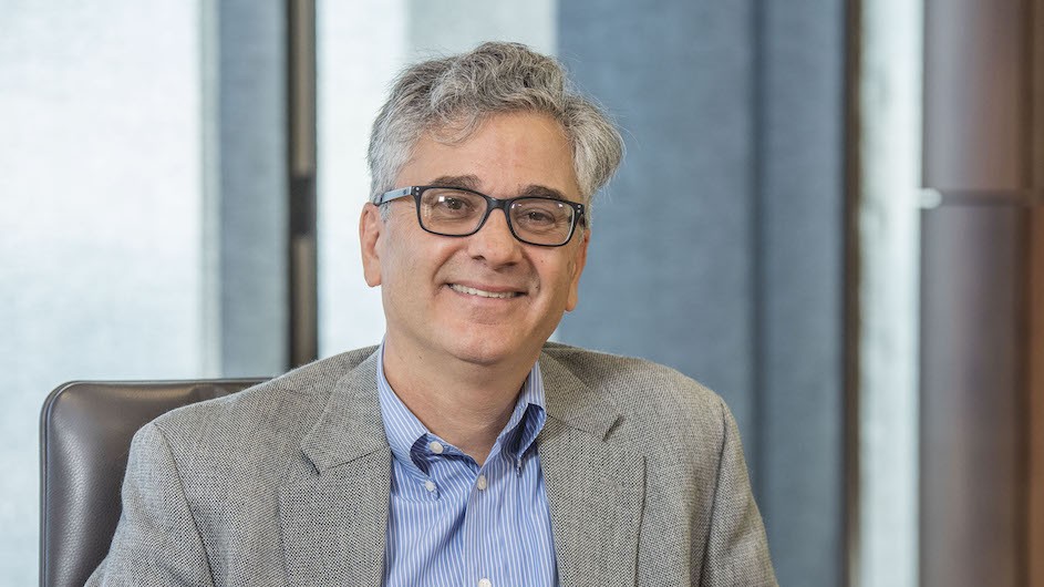 Vincent Schiraldi of Columbia University's School of Social Work, seated wearing a grey blazer and a light blue shirt