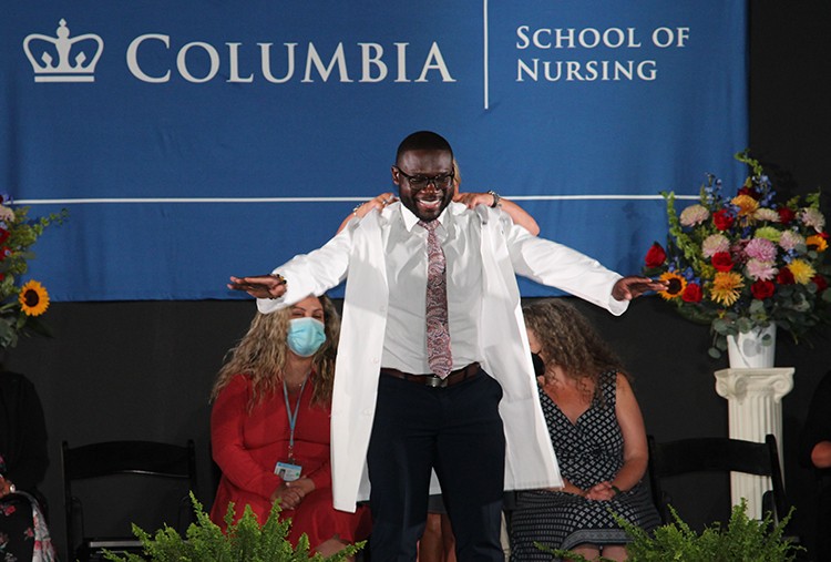 Part of orientation activities at Columbia Medical Center include "White Coat" ceremonies, ushering in new classes of nursing, dental, medical, and physical therapy students. Photo by Melissa O'Rourke. A Nursing School student has a white coat placed on him during the white coat ceremony.