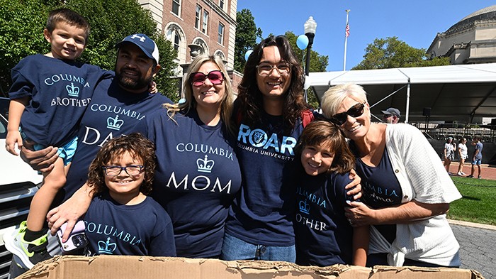 A family helps a new Columbia student move in. The whole family is wearing Columbia t-shirts.