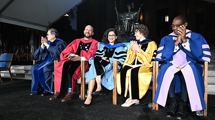 Columbia Engineering Dean Shih-Fu Chang, Columbia College Dean Josef Sorett, Columbia President Minouche Shafik, Dean of the Faculty of Arts and Sciences Amy Hungerford, and Interim Provost Dennis Mitchell applaud the incoming Class of 2027 at Columbia College and Columbia Engineering's Convocation ceremony. Photo by Eileen Barroso/Columbia College. Academic leaders of Columbia University sit in front of Alma Mater during Convocation.
