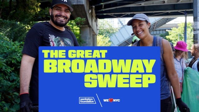 Two volunteers, a man and a woman, pose in front of a sign featuring the Great Broadway Sweep. 