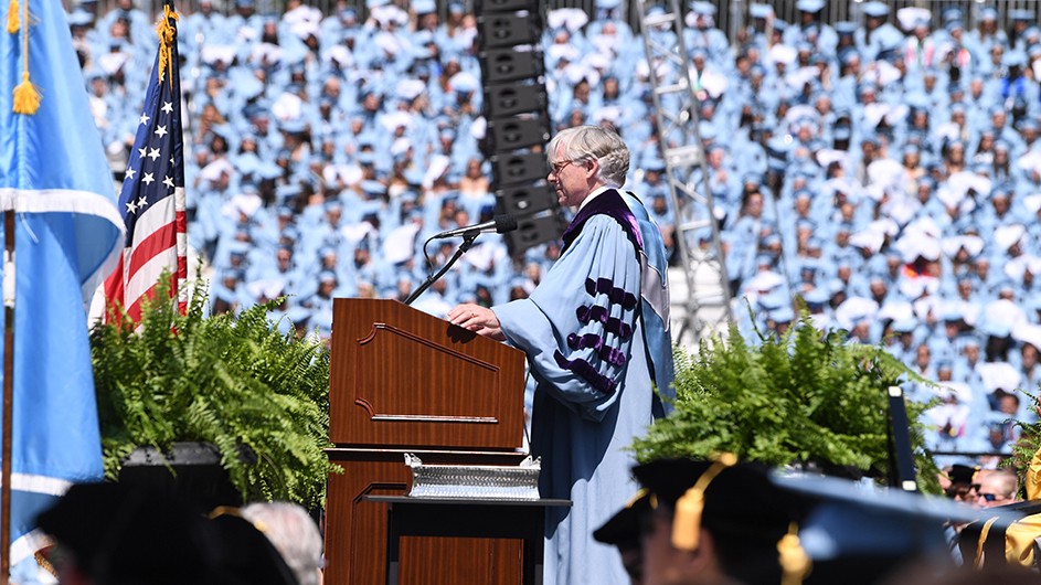 Photo: Eileen Barroso. Lee Bollinger standing in front of a lectern on graduation day, delivering his speech.
