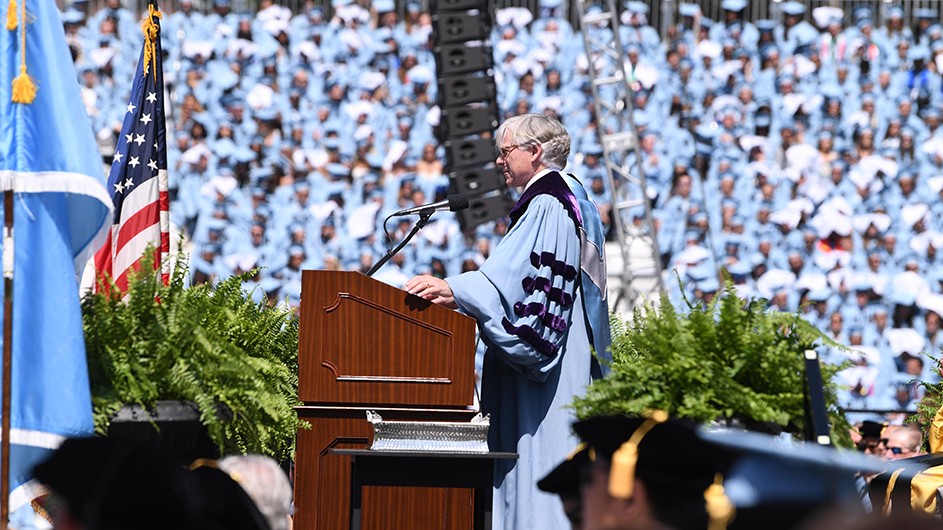 Lee Bollinger standing in front of a lectern on graduation day, delivering his speech. 