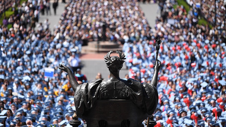 A view of the crowd at Commencement, from Low Library's steps, with the statue of Alma Mater in the foreground