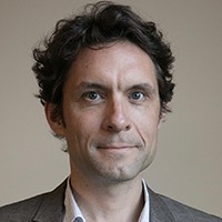 A man with short, dark hair in a suit.