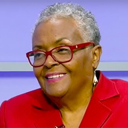 Joyce Ladner, a woman with short white hair and red glasses, in a red top. 