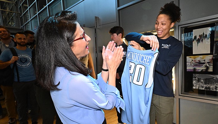 Minouche Shafik receives personalized Columbia jersey from student athlete