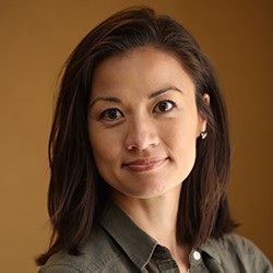 A woman with medium-length, dark hair, smiling. 