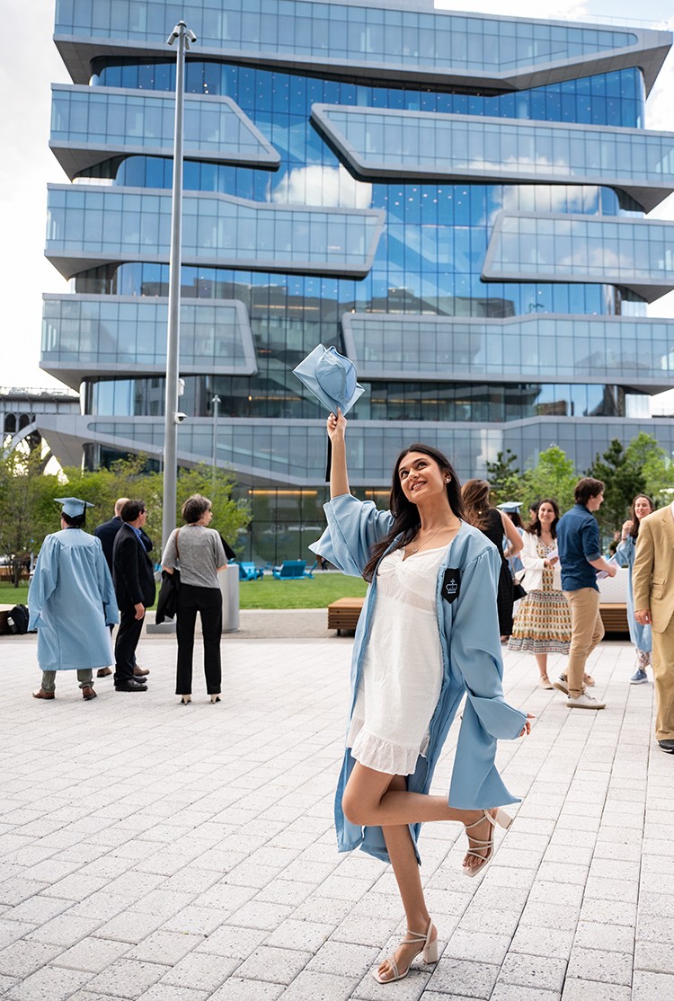 Lubna Patwa (BUS'22) poses in regalia in front of a Business School building.