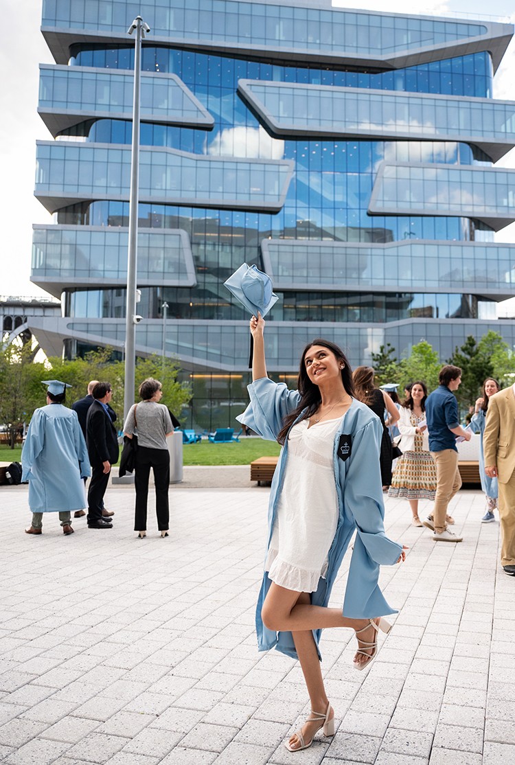 Lubna Patwa (BUS'22) photo by Diane Bondareff. Lubna Patwa (BUS'22) poses in regalia in front of a Business School building.