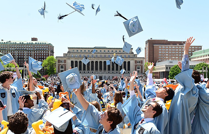 2023 graduates throw mortar boards in the air. 