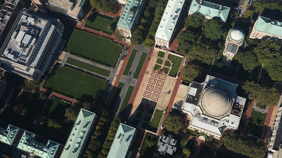 An aerial view of Low Library, Low Plaza, South Field Lawns, and other buildings and landmarks at Columbia University on a sunny day.