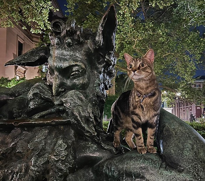 A cat poses on the Great God Pan statue