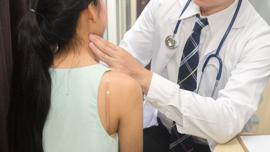A doctor examines a patient's neck.