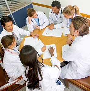 medical students sit around a table talking.