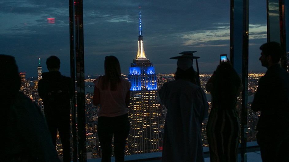 Columbia graduates take in the view of the Empire State Building from Summit One Vanderbilt. Photo by David Dini/Columbia University. The Empire State Building image ® is a registered trademark of ESRT Empire State Building, L.L.C. and is used with permission. The Empire State Building as viewed from Summit One Vanderbilt.