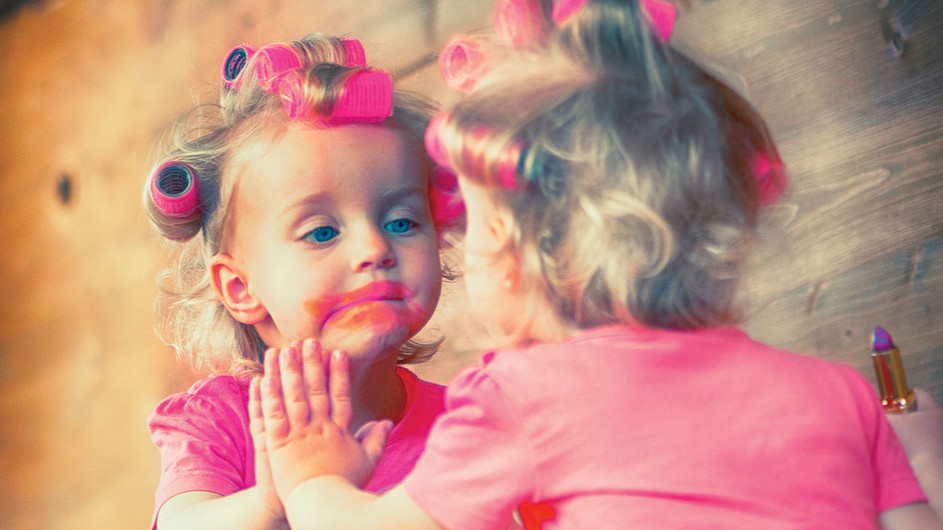 A child with smeared lipstick on her face.