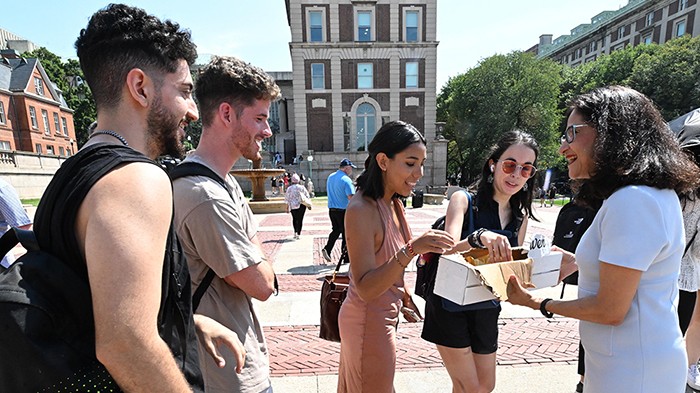 President Shafik offers ice cream to students in line for the ice cream truck.