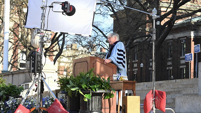 President Bollinger with film equipment around his records his Commencement speech during commencement. 