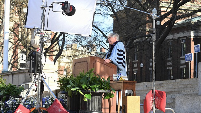 2021 photo by Eileen Barroso. President Bollinger with film equipment around his records his Commencement speech during commencement.